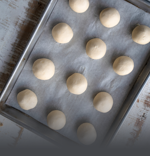 Bolitas de Pandeyuca para Hornear - Panadería El Molino Cali Bandeja con bolitas de masa cruda de pandeyuca tradicional preparadas y listas para hornear en casa, de Panadería El Molino, Cali.