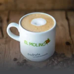 Taza de capuchino artesanal con espuma cremosa y arte latte, servida en Panadería El Molino, Cali, ideal para acompañar amasijos.