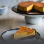 Chocoflan artesanal entero con abundante caramelo derretido sobre una base de madera rústica en Panadería El Molino, Cali.