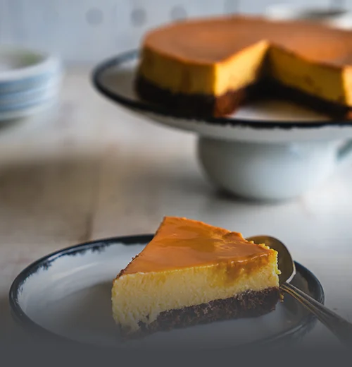 Chocoflan artesanal entero con abundante caramelo derretido sobre una base de madera rústica en Panadería El Molino, Cali.