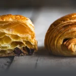 Croissant au chocolat recién horneado, hojaldre francés crujiente relleno de chocolate en Panadería El Molino, Cali.