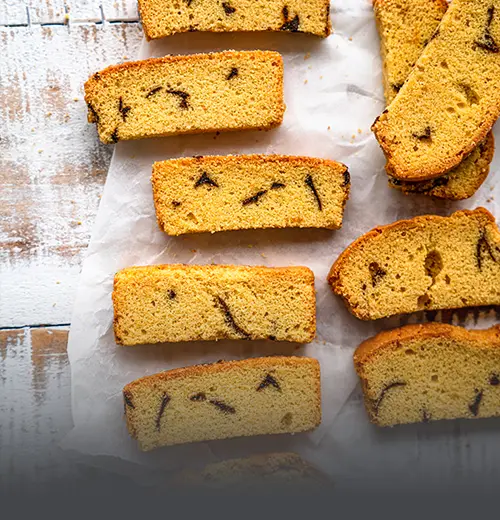Galleta Chocolatera Artesanal - Panadería El Molino Cali Tajadas de galleta chocolatera artesanal con trozos de chocolate, recién horneadas sobre papel para hornear en Panadería El Molino, Cali.
