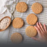 Canasta metálica rústica llena de galletas de avena artesanales y recién horneadas con textura visible de avena y frutos secos.