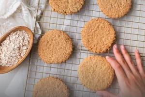 Canasta metálica rústica llena de galletas de avena artesanales y recién horneadas con textura visible de avena y frutos secos.