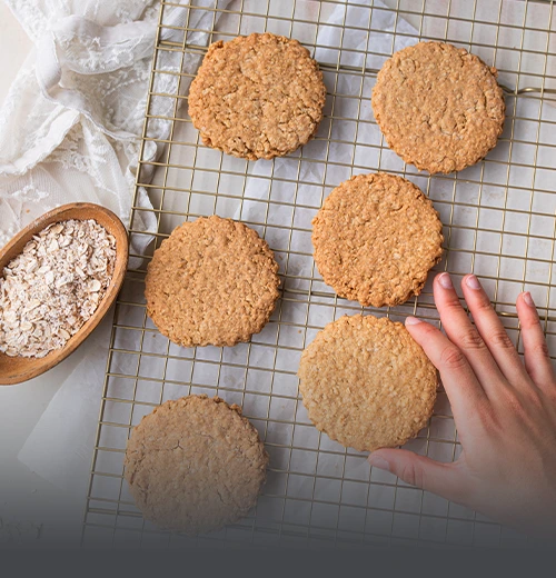 Galleta de Avena Casera - Panadería El Molino Cali Canasta metálica rústica llena de galletas de avena artesanales y recién horneadas con textura visible de avena y frutos secos.