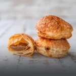 Glorias de arequipe artesanales en masa de hojaldre azucarada, mostrando su abundante relleno cremoso, elaboradas en Panadería El Molino, Cali.