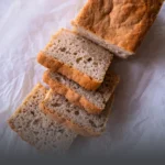 Hogaza y rebanadas de pan de arroz artesanal sin gluten, con miga aireada y corteza dorada, horneado en Panadería El Molino, Cali.