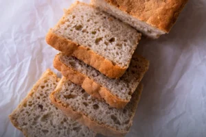 Hogaza y rebanadas de pan de arroz artesanal sin gluten, con miga aireada y corteza dorada, horneado en Panadería El Molino, Cali.