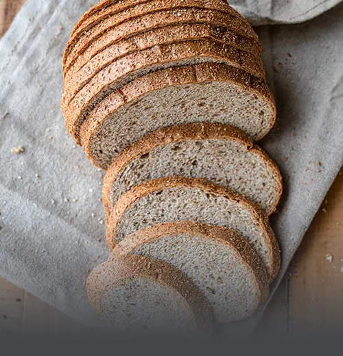 Pan Completo Integral de Grano Entero - Panadería El Molino Cali Hogaza rebanada de pan completo artesanal, elaborado con harina integral de grano entero en Panadería El Molino, Cali.