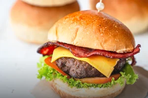 Pan de hamburguesa tipo brioche de papa artesanal, con textura suave y dorada, resaltando la calidad del pan en una hamburguesa armada en Panadería El Molino.