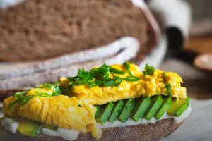 Pan hogaza artesanal tajado sobre una tabla de madera rústica, mostrando su miga aireada y corteza dorada en Panadería El Molino de Cali.