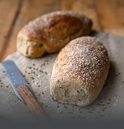 Pan Integral Multicereal con Quinua 20% - Panadería El Molino Cali Hogazas de pan integral multicereal artesanal enriquecido con un 20% de quinua, recién horneado en Panadería El Molino, Cali.