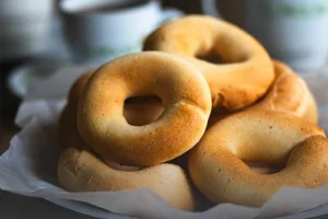 Pandebonos vallunos recién horneados y dorados en una canasta de mimbre sobre una mesa rústica en Panadería El Molino, Cali.
