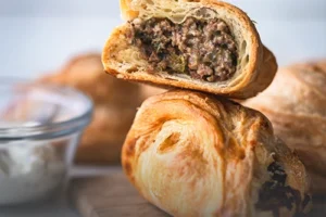 Pastel de carne tradicional, masa de hojaldre dorada y crujiente con relleno salado, horneado en Panadería El Molino, Cali.