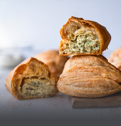Pastel de pollo tradicional, masa de hojaldre crujiente y dorada con un jugoso relleno salado, horneado en Panadería El Molino, Cali.