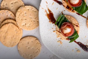 Tostadas de ajonjolí artesanales y crujientes, cubiertas de semillas, presentadas sobre una superficie de madera rústica en Panadería El Molino.