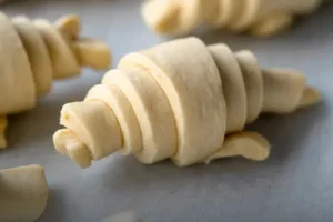 Bandeja con masa cruda de auténtico croissant parisino, listo para hornear en casa, elaborado por Panadería El Molino en Cali.