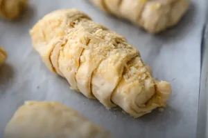 Bandeja con palitos de queso crudos en masa de hojaldre, listos para hornear en casa, elaborados por Panadería El Molino en Cali.