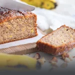 Porción de cake artesanal de banano y nuez siendo cortada, servido junto a bananos frescos y trozos de nuez en Panadería El Molino, Cali.