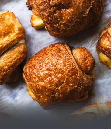 Croissants de queso artesanales y recién horneados. Hojaldre crujiente y fresco preparado a diario en Panadería El Molino, Cali.