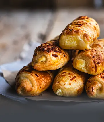 Palitos de queso artesanales recién horneados, crujientes y rellenos de queso. Producto natural y fresco de Panadería El Molino en Cali.