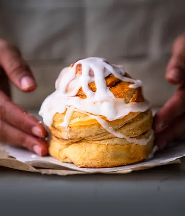 Rollo de canela artesanal, esponjoso y recién horneado. Un postre dulce y natural para tu break en Panadería El Molino, Universidad Javeriana Cali.